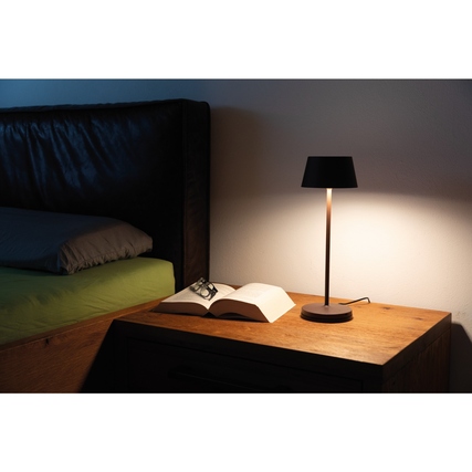 Tischleuchte in braun auf einem Nachttisch mit Buch und Brille daneben.