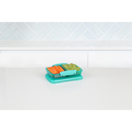 Bunte Lunchbox mit zwei Fächern und frischem Gemüse und Trauben auf einem Tisch.
