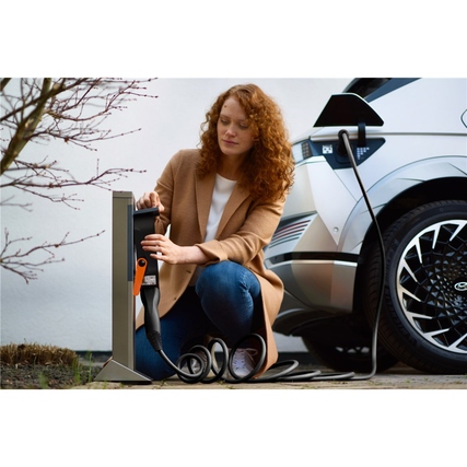 Eine Person lädt ein Elektroauto mit einem schwarzen LAPP Ladekabel an einer Ladestation.