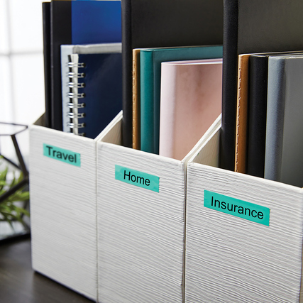 Grüne DYMO® Schriftbandetiketten an weißen Boxen zur Beschriftung von Ordnern.