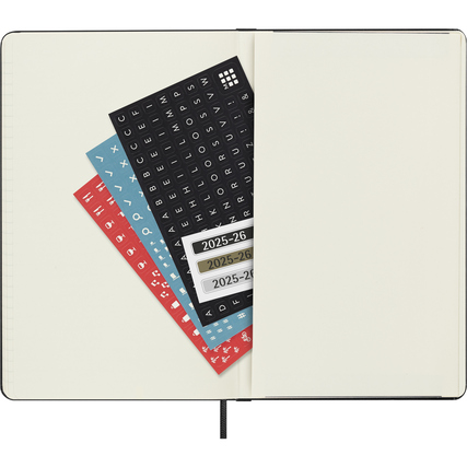 Drei farbige Stickervorlagen liegen offen in einem Moleskine Buchkalender.