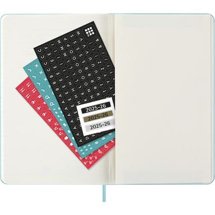 Blick in einen Moleskine Buchkalender mit bunten Aufklebern und leeren Seiten.