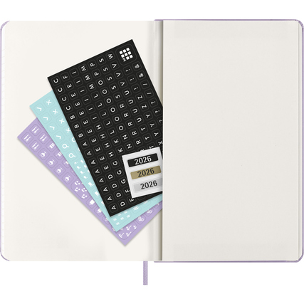 Blick auf einen offenen Moleskine Buchkalender mit bunten Aufklebern und leeren Seiten.
