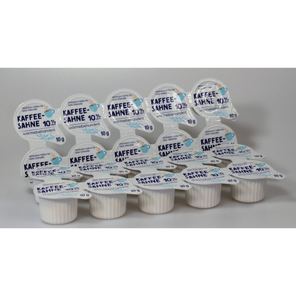 Kaffeekapseln mit Aufdruck "Kaffee-Sahne 10%" in einem Stapel angeordnet.