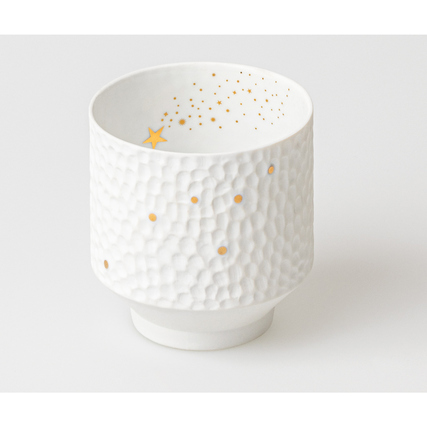 Weißes Windlicht aus Porzellan mit Hammerschlag-Optik und goldenen Sternen-Illustrationen.