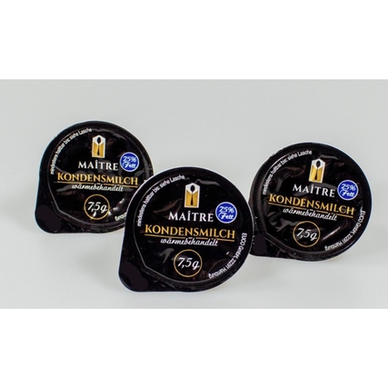 Drei Portionsbecher mit Maitre Kondensmilch auf hellem Hintergrund.