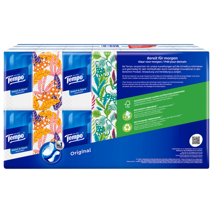 Packung mit Tempo Papiertaschentüchern in verschiedenen Designs auf blauer Hintergrund.