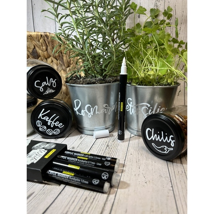 Acrylmarker in Einsatz zur Beschriftung von Pflanzenkübeln mit Kräutern und weiteren Stiften.