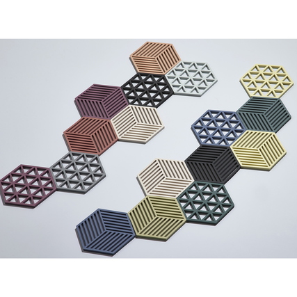 Sechseckige Topfuntersetzer in verschiedenen Farben und Mustern auf einem hellen Hintergrund.