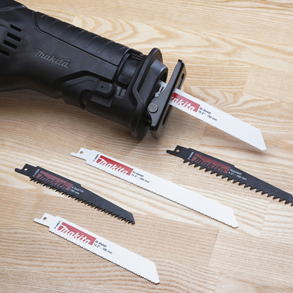 Sägemaschine mit vier Sägeblättern in verschiedenen Formen auf Holzoberfläche.