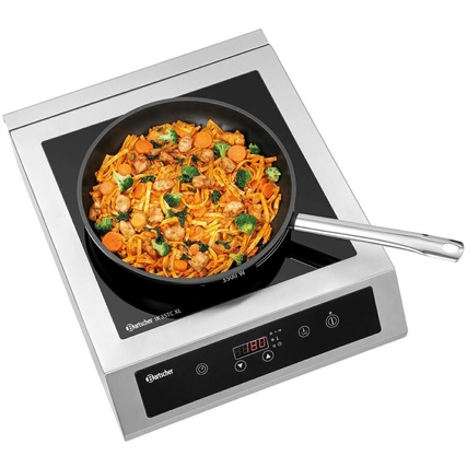 Induktionskochplatte mit Pfanne und Gemüsegericht, zur Zubereitung auf großer Kochstelle.