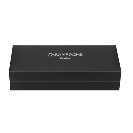 Schwarze Geschenkbox mit rotem Streifen und dem Logo von Caran d'Ache auf der Oberseite.