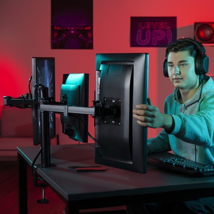 Monitorschwenkarm mit drei Armen, montiert am Tisch, unterstützt mehrere Bildschirme.