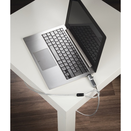 Notebookschloss befestigt an einem Laptop, der auf einem weißen Tisch steht.