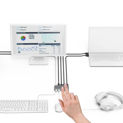 KVM-Switch mit angeschlossenem Monitor, Laptop, Tastatur und Maus in einem Arbeitsumfeld.