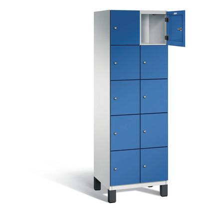 Hochschrank mit zehn Fächern, lichtgrau mit einer blau lackierten Tür, teilweise geöffnet.