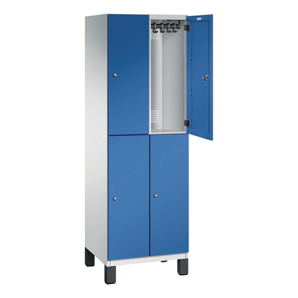 Doppelstöckiger Kleiderschrank in lichtgrau und enzianblau mit offener Tür und Garderobenstange.