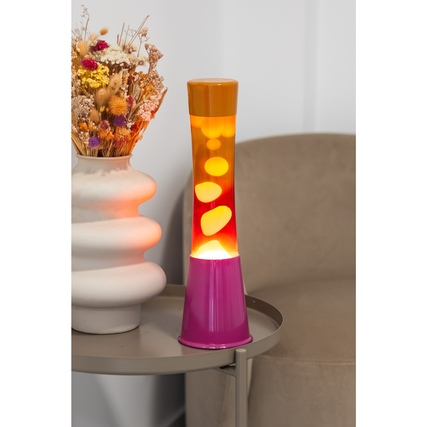 Lavalampe in Pink und Orange auf einem Tisch neben einer dekorativen Blumenvase.