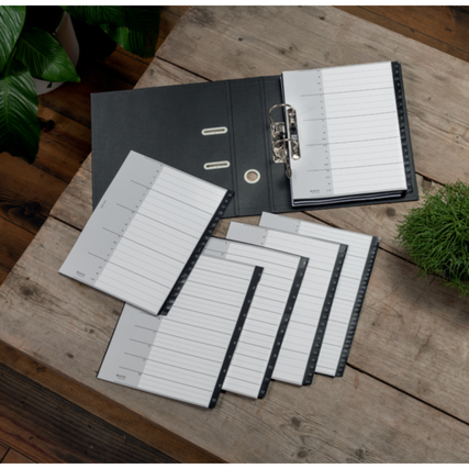 Zahlenregister mit zwölf nummerierten Blättern auf einem Tisch neben einem Ordner und Pflanzen.