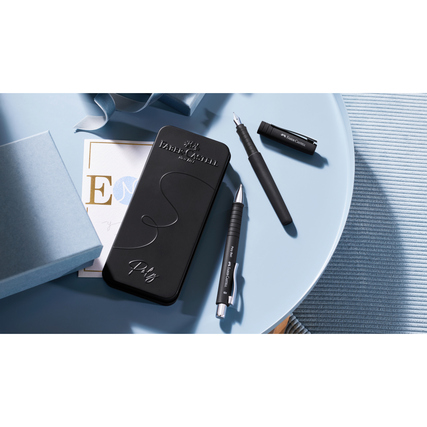 Schreibgeräteset in schwarze Geschenkverpackung mit Füller und Kugelschreiber auf einem Tisch.