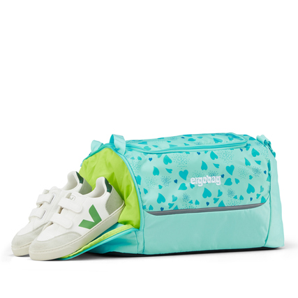 Türkisfarbene Sporttasche mit grünem Innenfutter und separatem Schuhfach, daneben Schuhe.