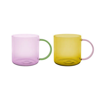 Grün und gelb transparente Becher aus Borosilikatglas mit farbigen Griffen.