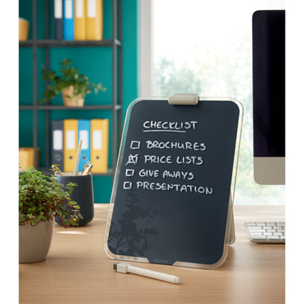 Graues Glasboard steht auf einem Tisch mit Notizen und dekorativen Elementen im Hintergrund.