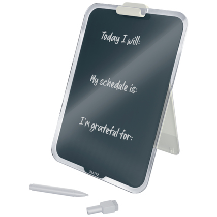 Graues Glasboard steht auf einem Tisch, beschriftet mit Notizen und einem Stift daneben.