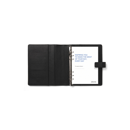 Schwarzer Filofax Organiser im DIN A5 Format mit geöffneten Ringen und leerem Notizblatt.