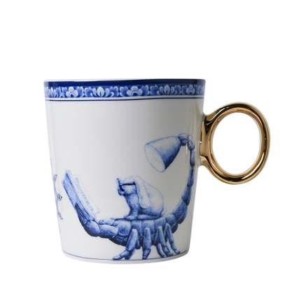 Tasse mit goldfarbenem Griff und blauer Skorpion-Illustration auf weißem Hintergrund.