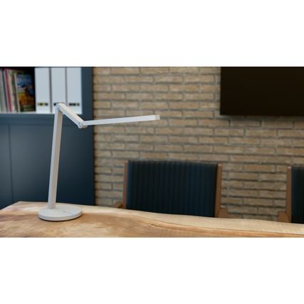 Tischleuchte mit schlankem Gelenkarm und flachem Leuchtenkopf auf einem Schreibtisch.