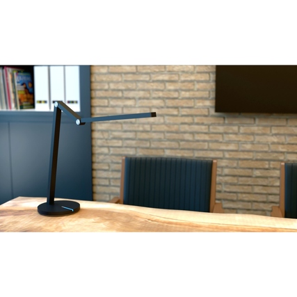 Schwarze Tischleuchte mit schwebender Optik und minimalistischem Design auf einem Holztisch.