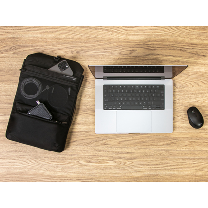 Rucksack mit abnehmbaren Tech-Organizer auf einem Tisch neben einem Laptop und Zubehör.