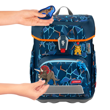 Ranzenaccessoire mit Dinosaurier-Anhängern während des Anbringens an einen Schulranzen.