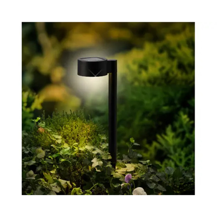 Solarleuchte in Schwarz, im Einsatz im Garten, mit warmweißer LED-Beleuchtung.