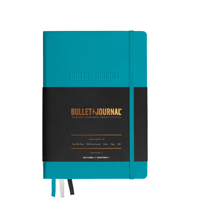 Türkises Notizbuch der Bullet Journal Edition 2 mit schwarzem Umschlag und Band.