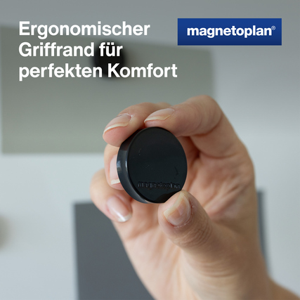 Schwarzer Ergo-Magnet in Hand mit ergonomischem Griffrand und unscharfem Hintergrund.
