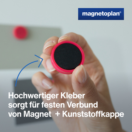 Ergo-Magnet in pink, gehalten von einer Hand, zeigt die spezielle Haftkraft und Kleber.