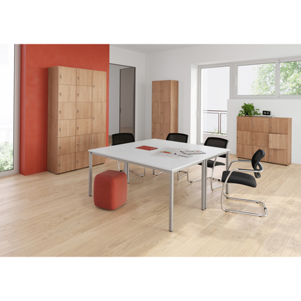 Büroumgebung mit einem nussbaumfarbenen Schließfachschrank und einem Besprechungstisch.