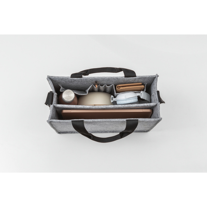 Graue Aufbewahrungstasche mit Büroutensilien, aus der Vogelperspektive fotografiert.