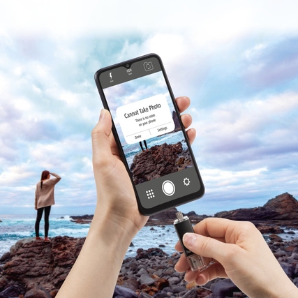 Person hält Smartphone mit USB-Stick am Strand, Bildschirm zeigt Fehlermeldung an.