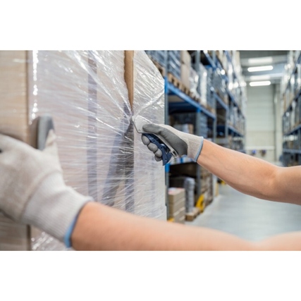 Sicherheitsmesser in der Hand eines Benutzers beim Öffnen eines verpackten Sacks in einem Lager.