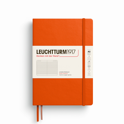 Notizbuch in leuchtendem Orange mit Hardcover, liniert und Band zum Schließen im A5-Format.