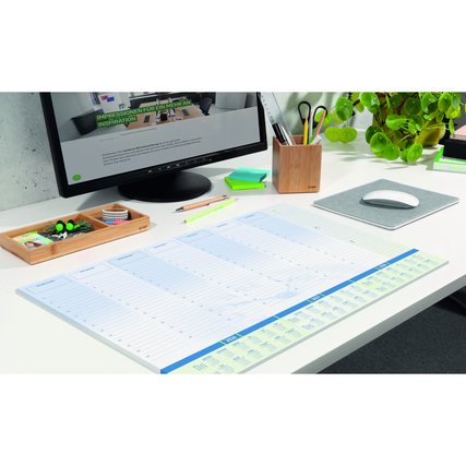 Schreibunterlage mit Kalender für 3 Jahre auf einem Schreibtisch, umgeben von Büromaterialien.
