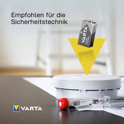 Varta Ultra Lithium E-Block Batterie über einem Rauchmelder auf einem Tisch platziert.