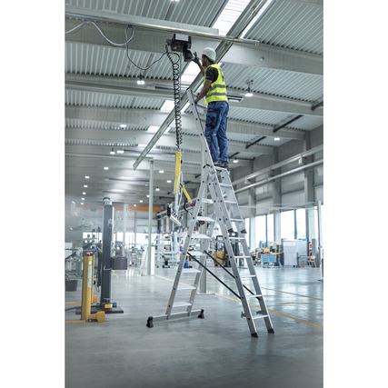 Multifunktionsleiter in Verwendung, Person arbeitet in einer Industriehalle mit Höhenverstellung.