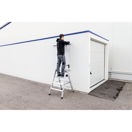 Klapptritt mit Person, die an einer Wand arbeitet, in stabiler Ausführung und sicherem Stand.