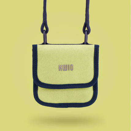 Brustbeutel in Lime mit schwarzem Rand und Karabinern, hängend auf einem gelben Hintergrund.