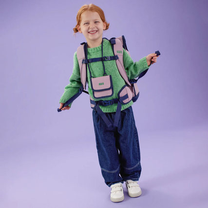 Brustbeutel SNAPP Pearl, getragen von einem Kind mit Rucksack vor lila Hintergrund.