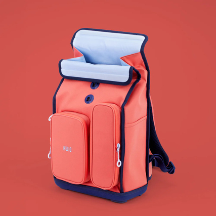 Schulrucksack in bunten Farben mit zwei Taschen und Rolltop-Verschluss auf rotem Hintergrund.